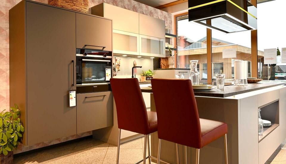 Eine Küche mit zwei roten Stühlen und einer großen Kochinsel.