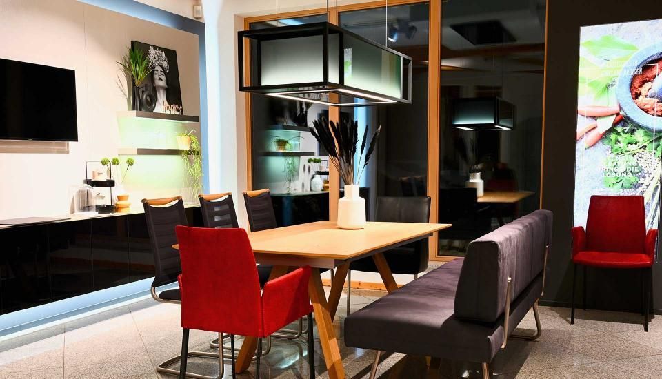 Ein Esszimmer mit Tisch, Stühlen und einer Bank.