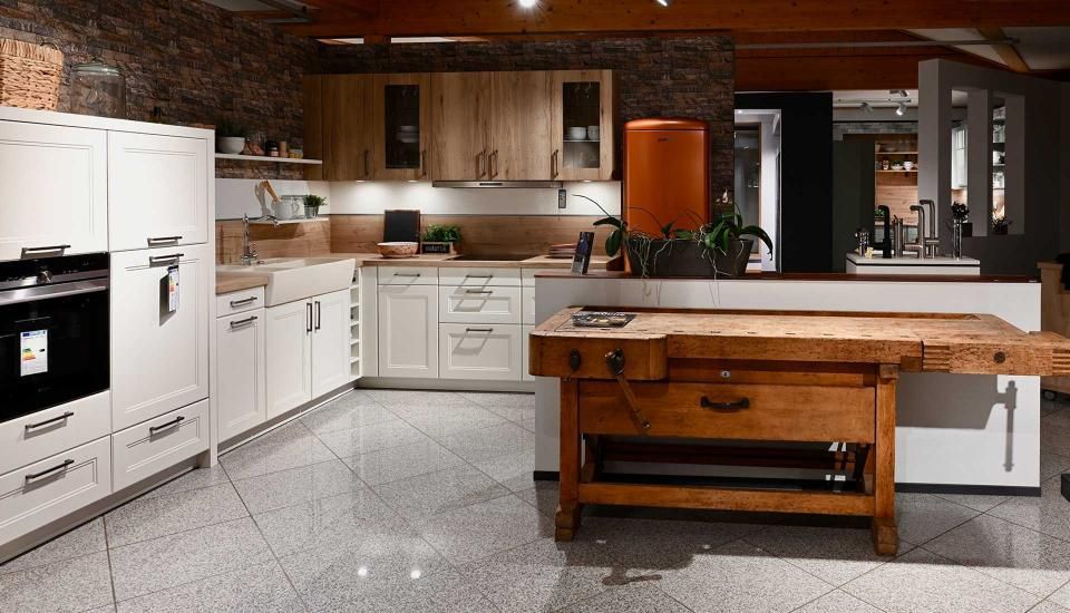 Eine Küche mit weißen Schränken und einer Werkbank aus Holz