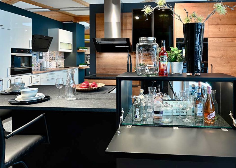 Eine Küche mit einer Bar und einem Tisch mit Gläsern darauf.
