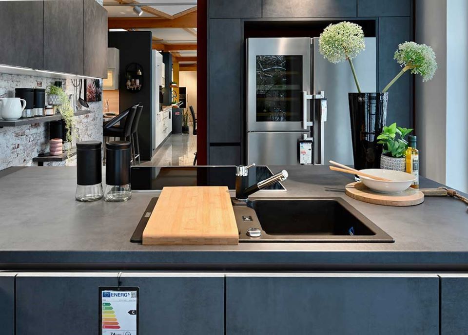 Eine Küche mit Spüle, Kühlschrank, Herd und Schneidebrett.