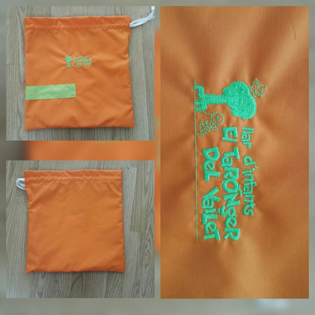Una bolsa naranja con un bordado verde.
