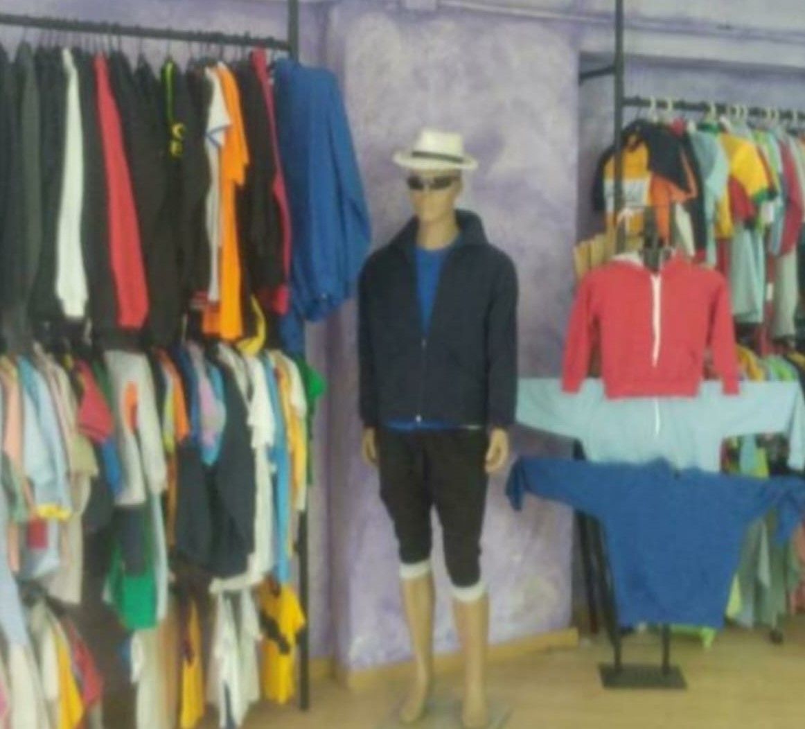 Un maniquí con sombrero y gafas de sol se encuentra en una tienda de ropa.