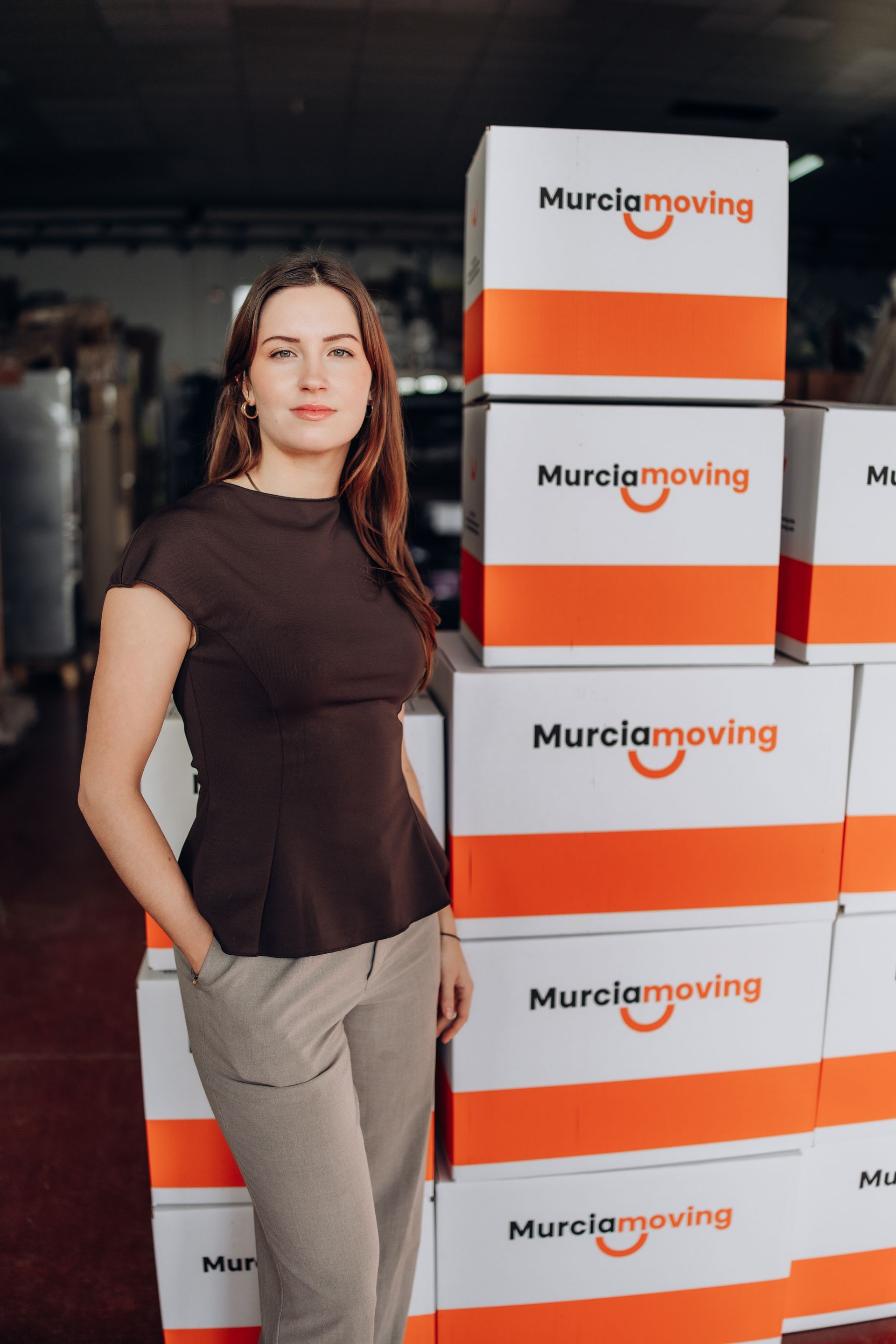 Paseo costero con palmeras, edificios y un castillo en lo alto de una colina rocosa bajo un cielo azul.