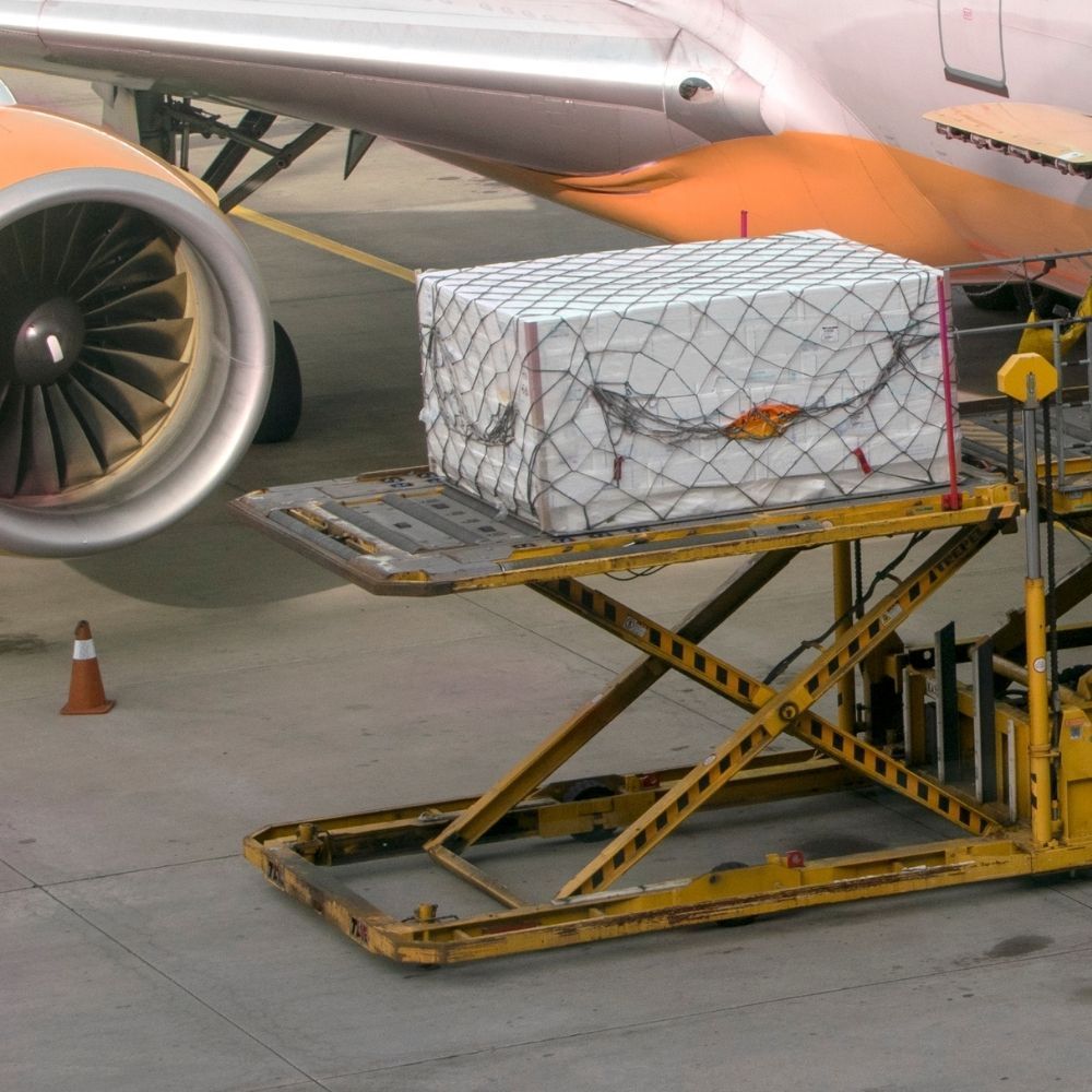 Mano que alcanza una caja de cartón en un estante de un almacén.