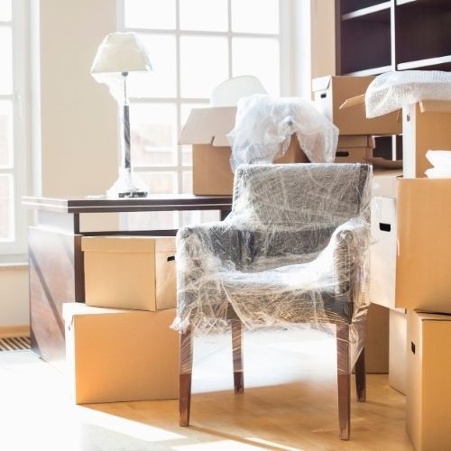 Paseo marítimo con palmeras, edificios y una gran estructura rocosa con un edificio moderno en Alicante, España.