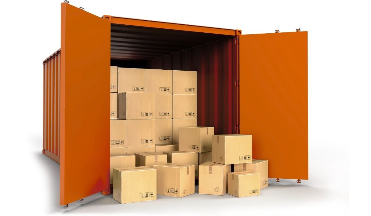 Mujer empacando una caja, colocando plástico de burbujas alrededor de un artículo decorativo, hombre empacando en el fondo.