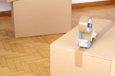 Un rollo de cinta está encima de una caja de cartón.