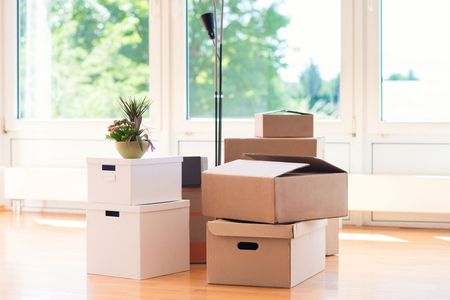 Un montón de cajas de cartón están apiladas una encima de otra en una habitación vacía.