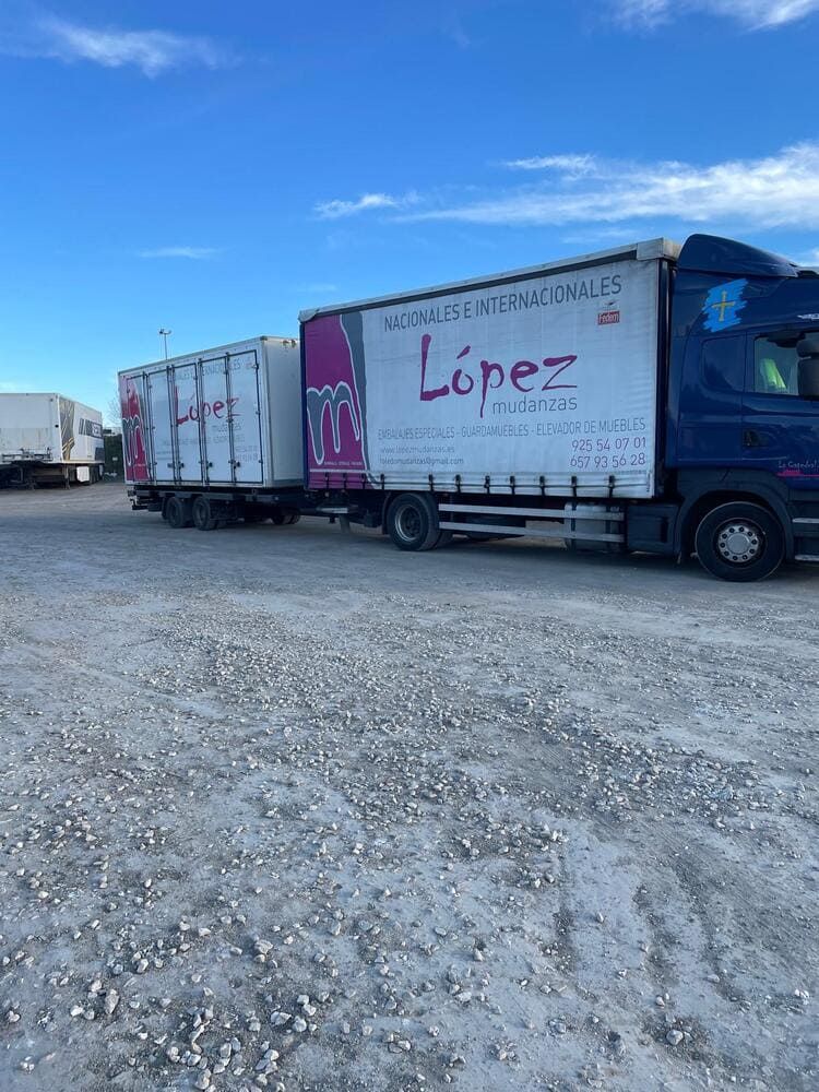 Parte trasera de un camión de mudanzas blanco con el logotipo rosa de 