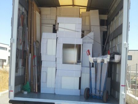 Dentro de un camión lleno de artículos para el hogar, incluidas puertas, marcos y cajas, listos para ser trasladados.