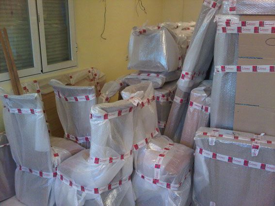 Muebles embalados, envueltos en plástico y cinta, listos para mudarse.