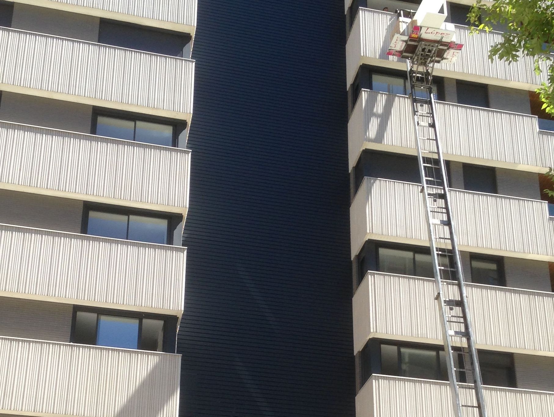 Un camión de mudanzas se eleva contra un edificio para trasladar muebles a un apartamento.