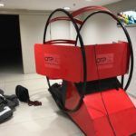 Pod Ora Fitness de color rojo, estructura negra y suelo blanco y negro, en el interior de un edificio.