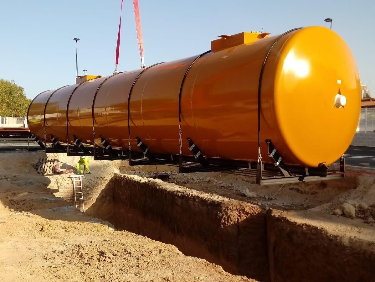 Un gran tanque naranja está tirado en el suelo.