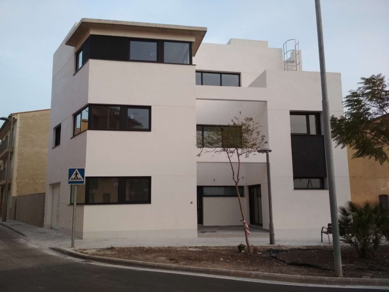 Un edificio blanco con un cartel azul que dice