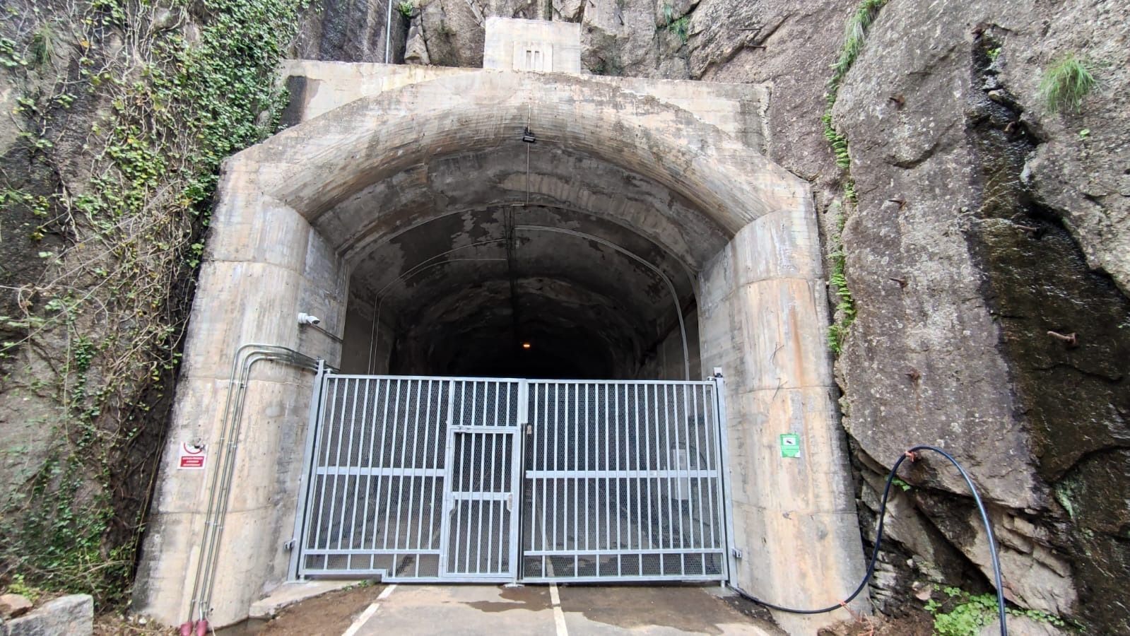 Un túnel con una puerta en el medio está rodeado de rocas.