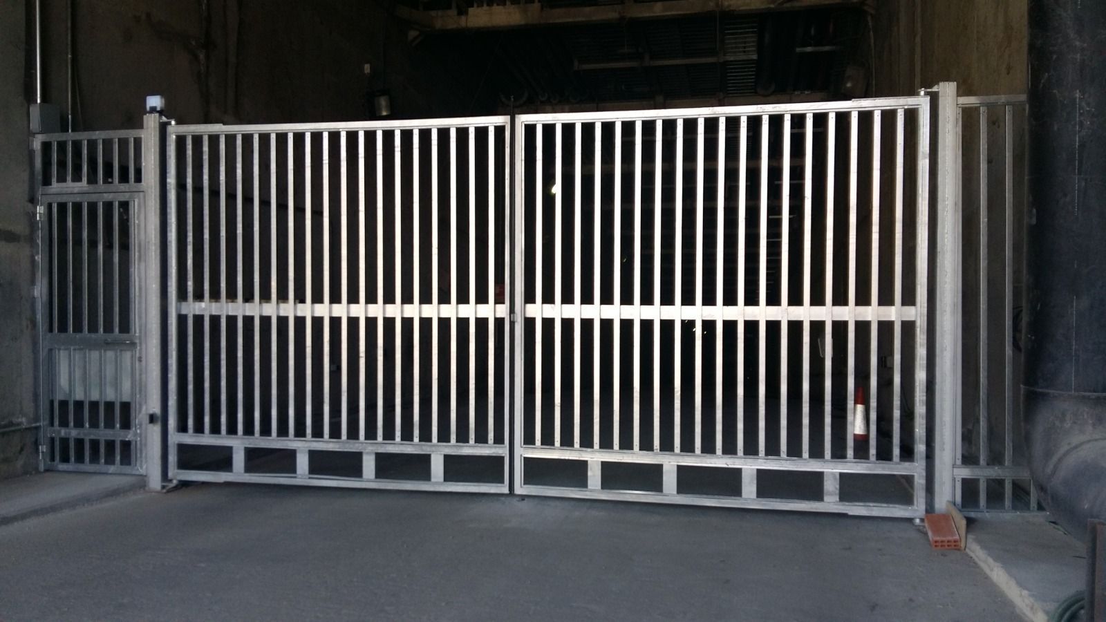 Una puerta de metal está cerrada en un estacionamiento.