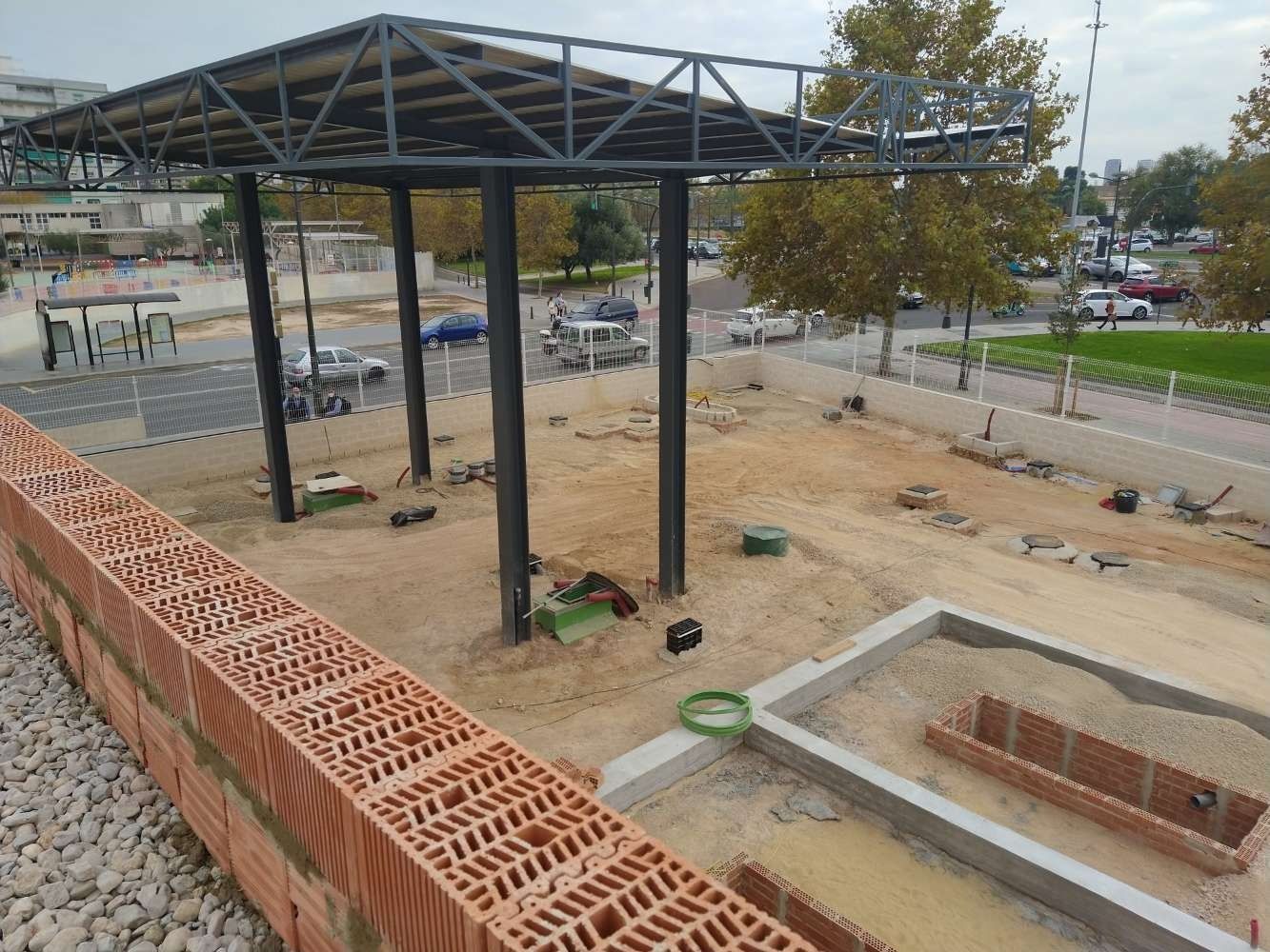 Se está construyendo un muro de ladrillos frente a un edificio en construcción.