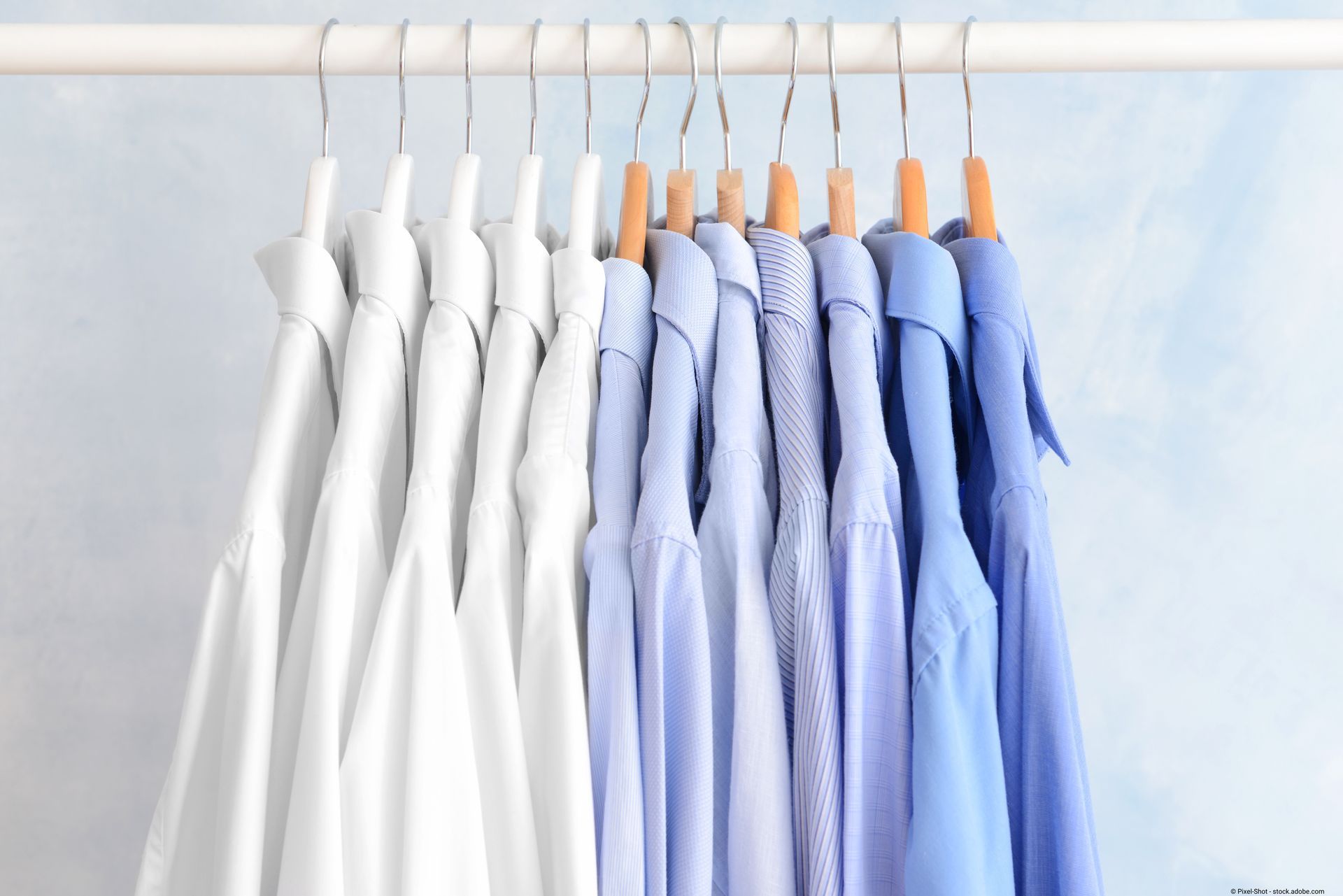 eine Reihe von gereinigten Hemden hängt an einem Wäscheständer