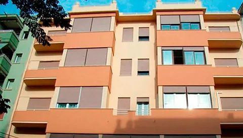 Un gran edificio de apartamentos con muchas ventanas y balcones.