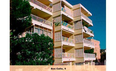 Un edificio grande con muchos balcones y árboles en el frente.