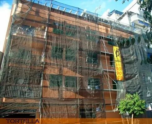 Un edificio en construcción con andamios y un letrero que dice tortilla