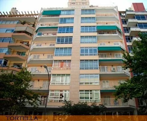 Un edificio alto con un cartel que dice tortella.