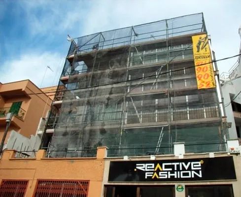 Un edificio con andamios y un cartel que dice moda reactiva.