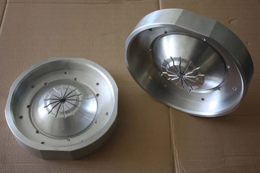Zwei Metallfelgen oder Radkappen, eine aufrecht und eine geneigt, auf einer Kartonoberfläche