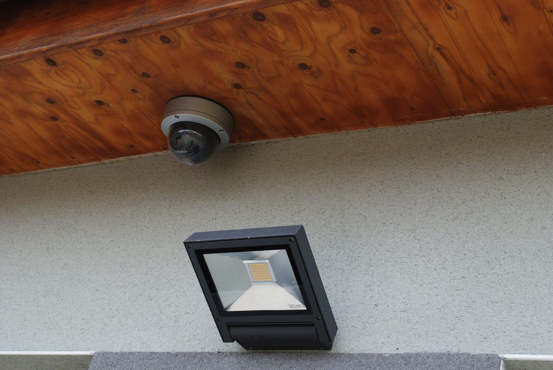Caméra de sécurité et projecteur installés à l'extérieur d'un bâtiment.
