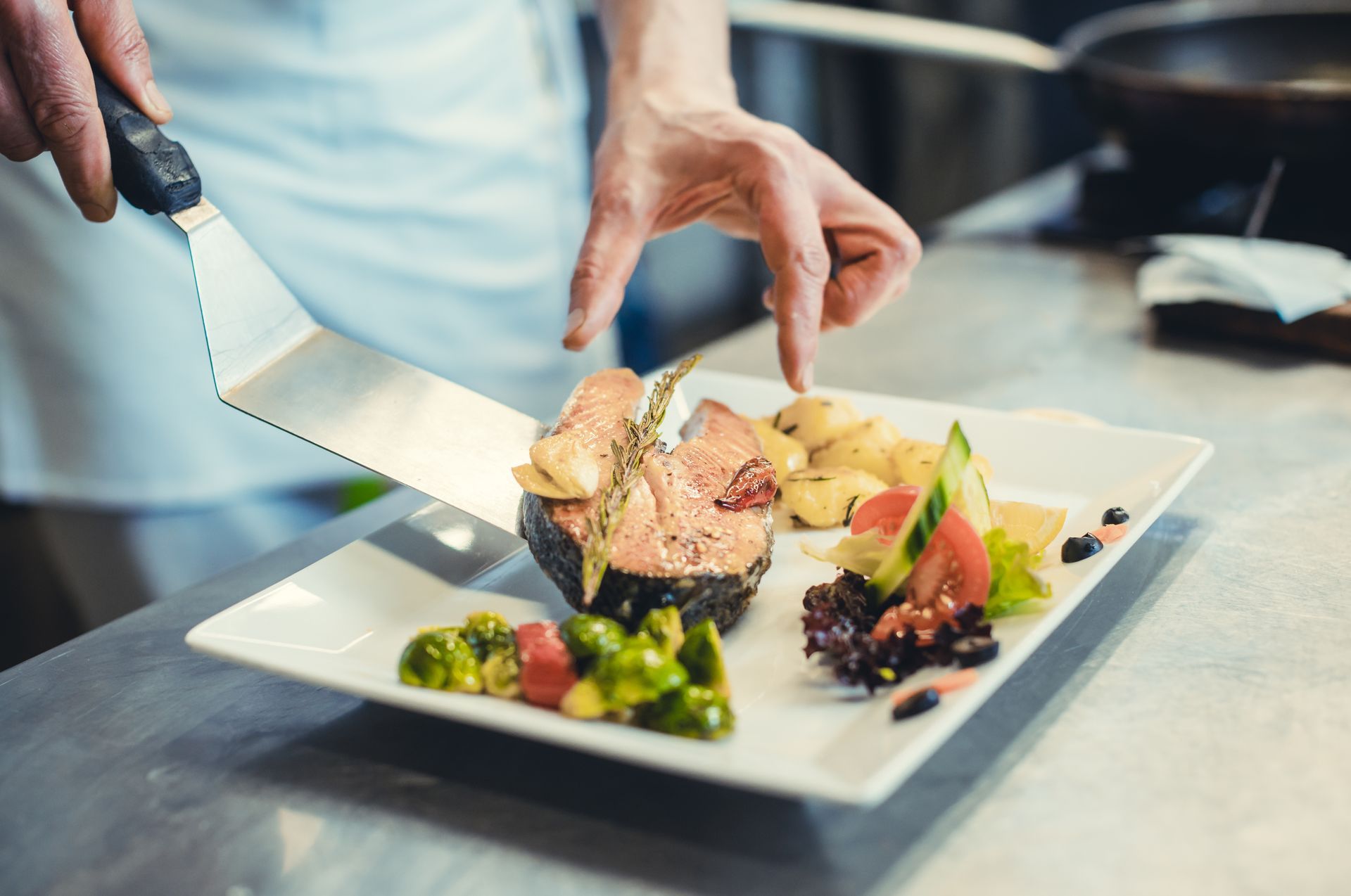 Un chef cuisinier termine un plat de poisson