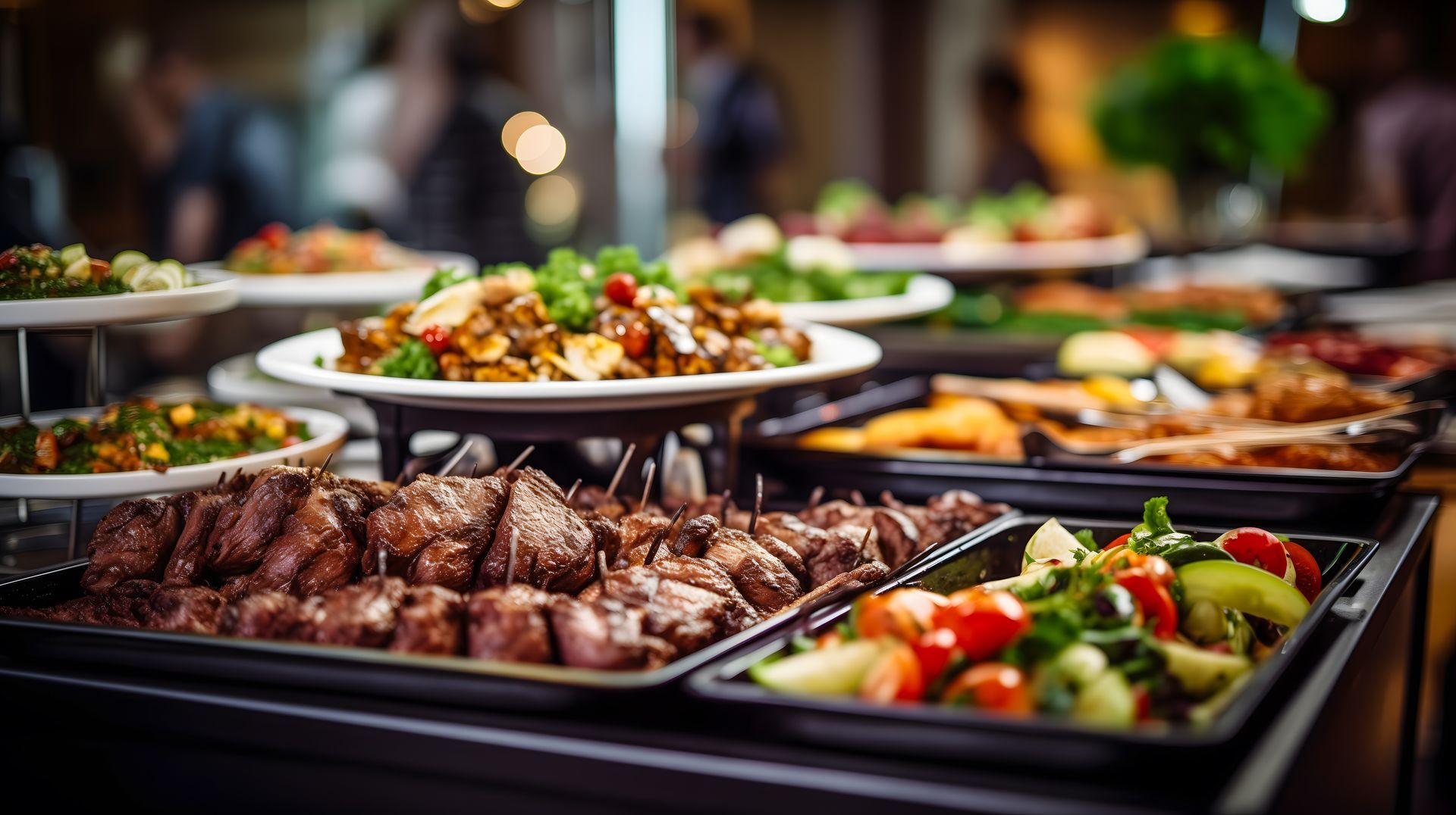 Buffet avec assortiment de plats chauds, salades et brochettes dans des plateaux en acier inoxydable.