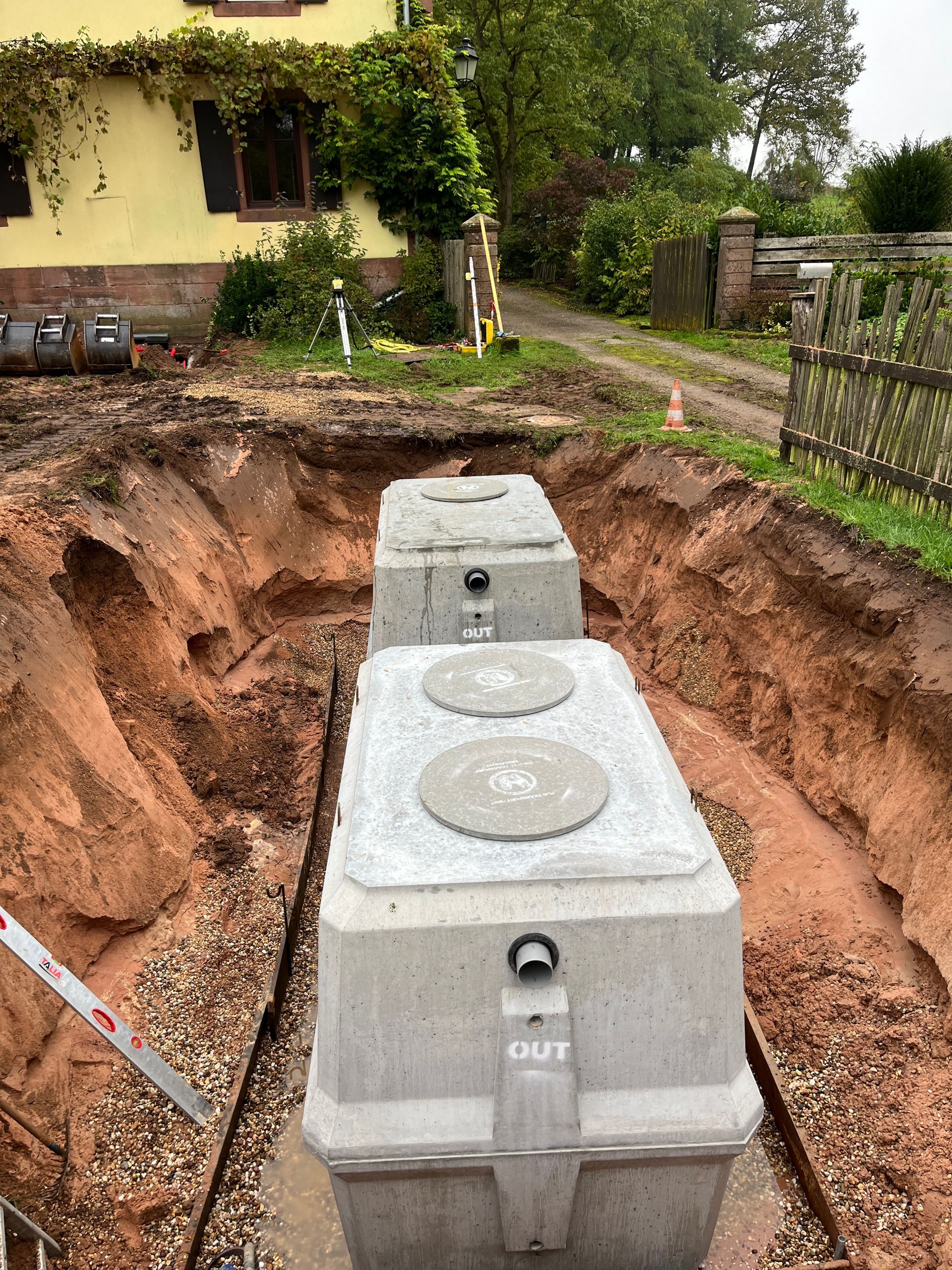Deux microstations grises posées dans une tranchée.