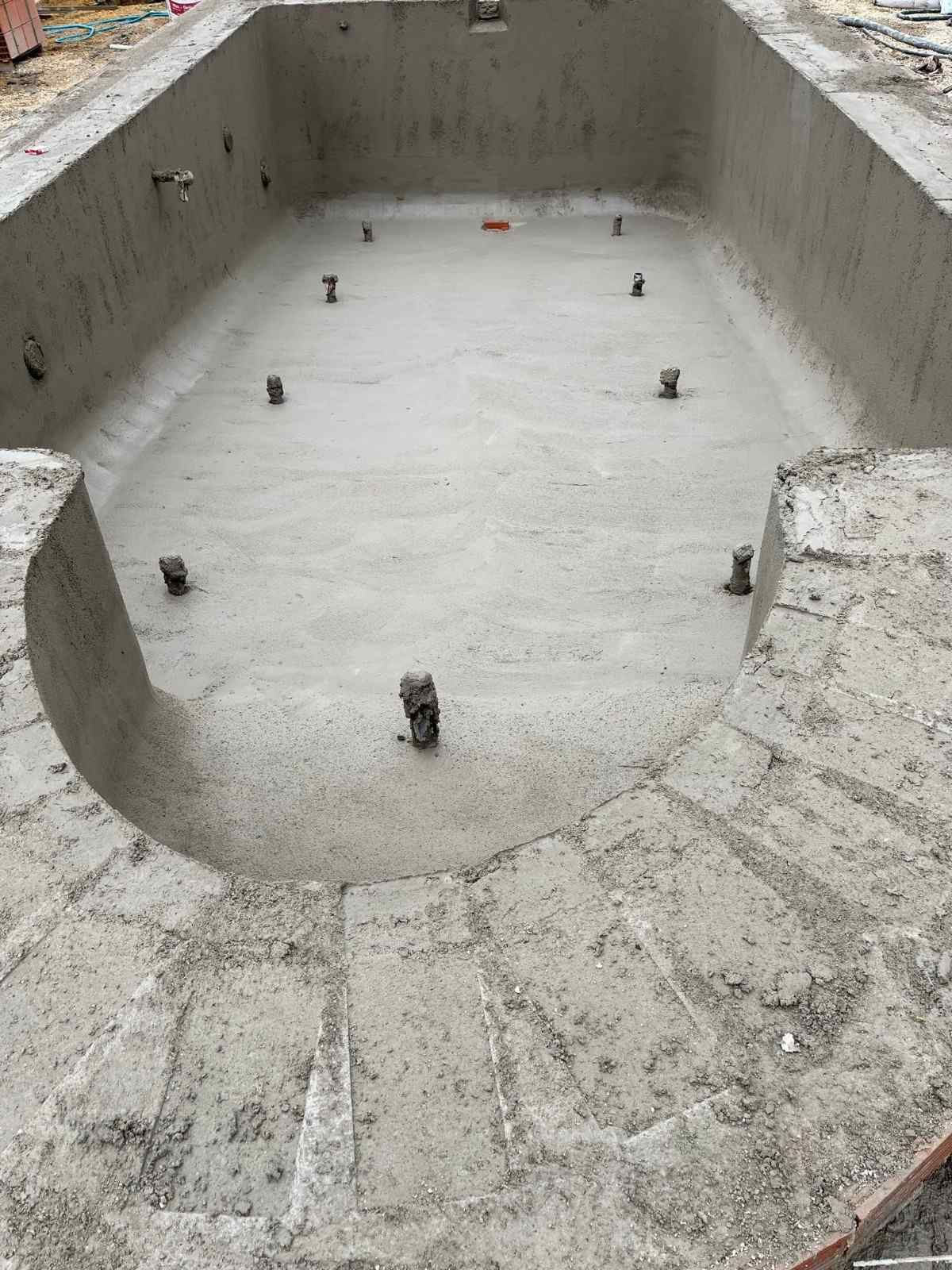 Piscina de nueva construcción con paredes y suelo de hormigón; marco de ladrillo.