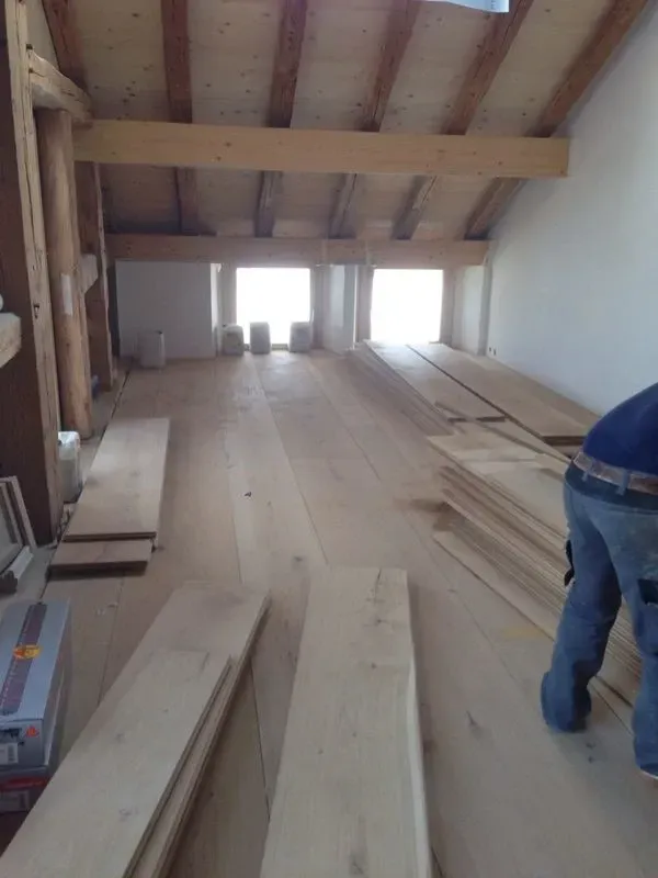 Porte ouverte donnant sur un couloir lumineux avec parquet clair