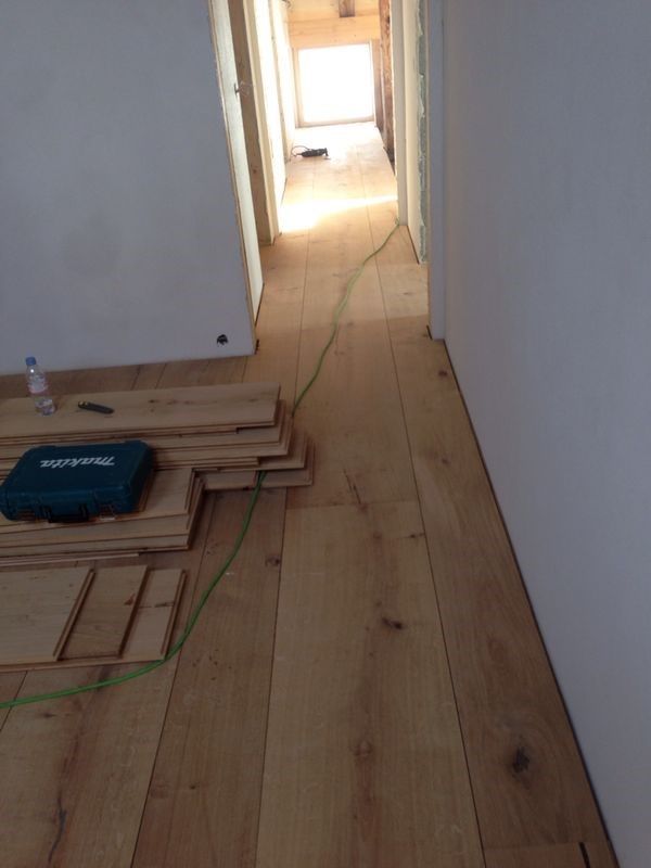 Cuisine et salle à manger modernes et lumineuses avec parquet, îlot central, étagères ouvertes et grandes fenêtres