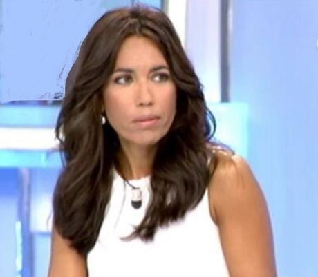Mujer con cabello largo y oscuro, vestida con una camiseta blanca sin mangas, mirando ligeramente hacia un lado