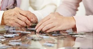 Ein Mann und eine Frau spielen zusammen ein Puzzle.