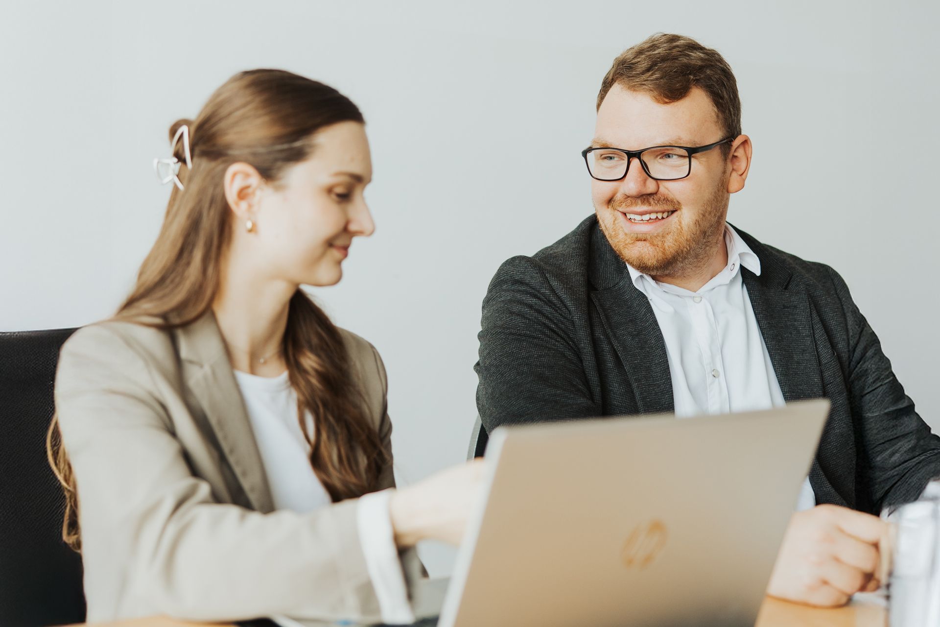 Zwei Geschäftsleute in Businesskleidung arbeiten zusammen.