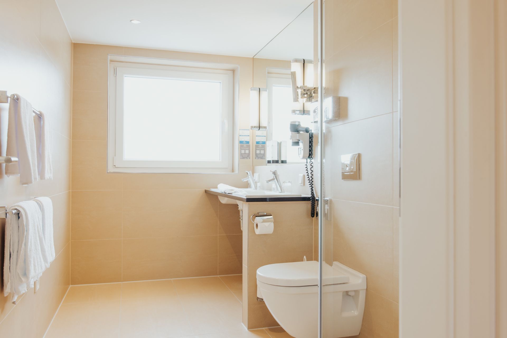 Ein Badezimmer mit Toilette, Waschbecken und Fenster.