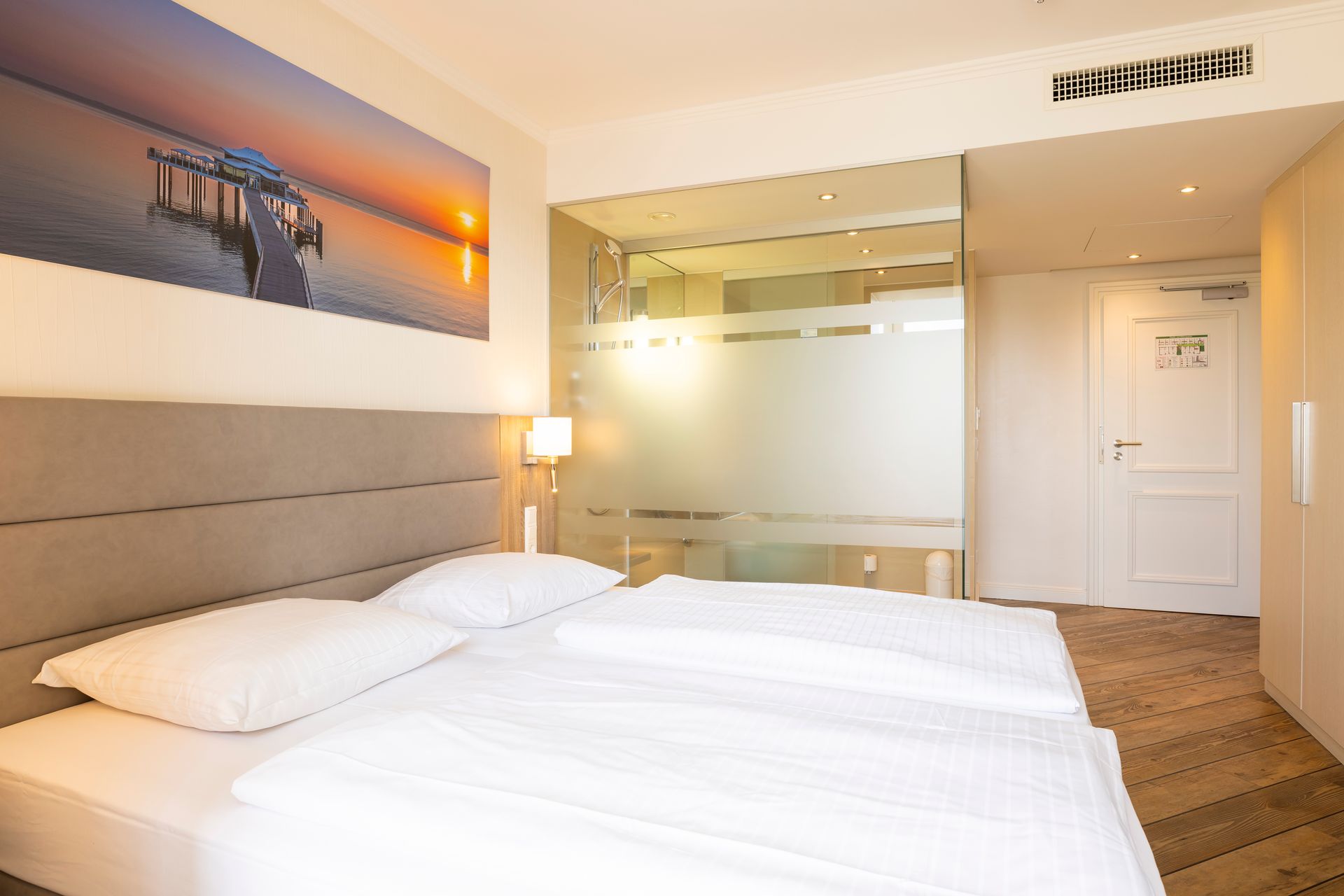 Ein Hotelzimmer mit zwei Betten und einem Bild an der Wand