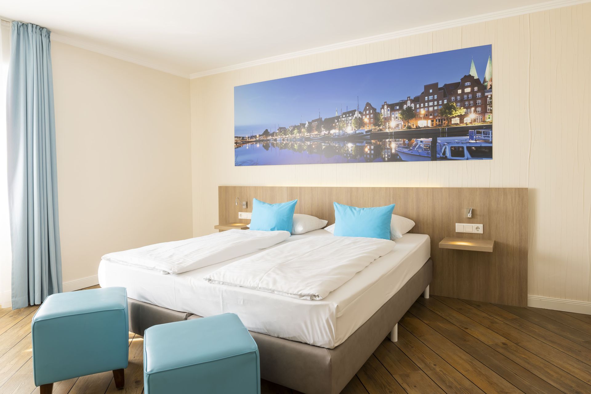 Ein Hotelzimmer mit zwei Betten und einem großen Gemälde an der Wand.