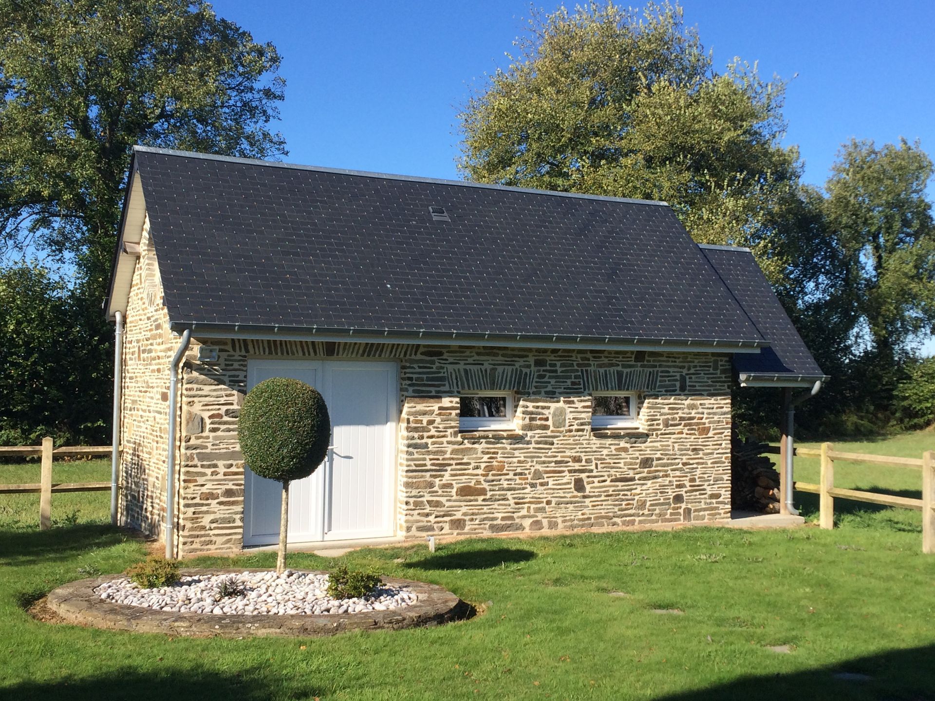 Un cabanon en pierre dans un jardin entretenu