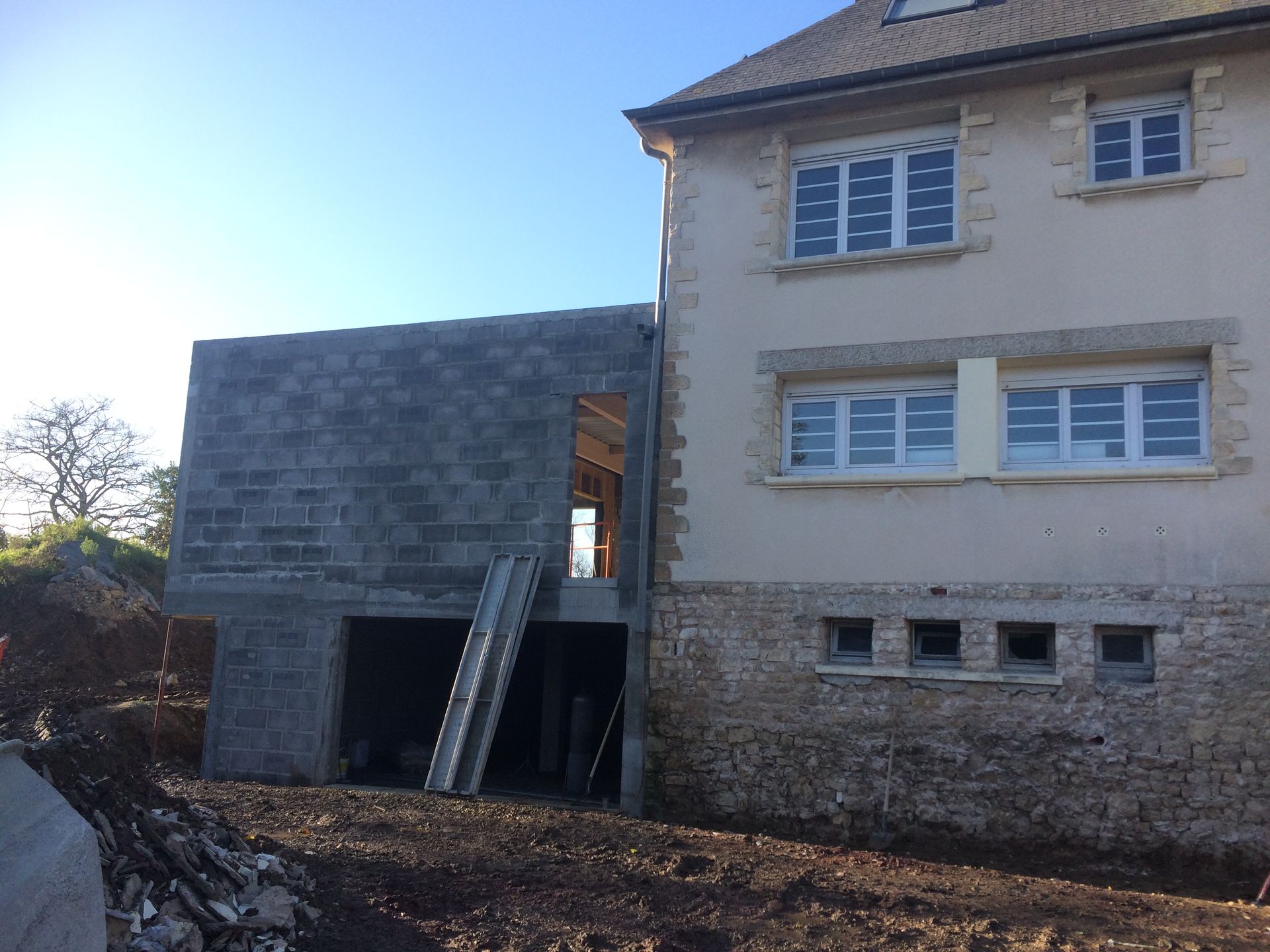 Façade d'une maison avec son extension en cours de construction