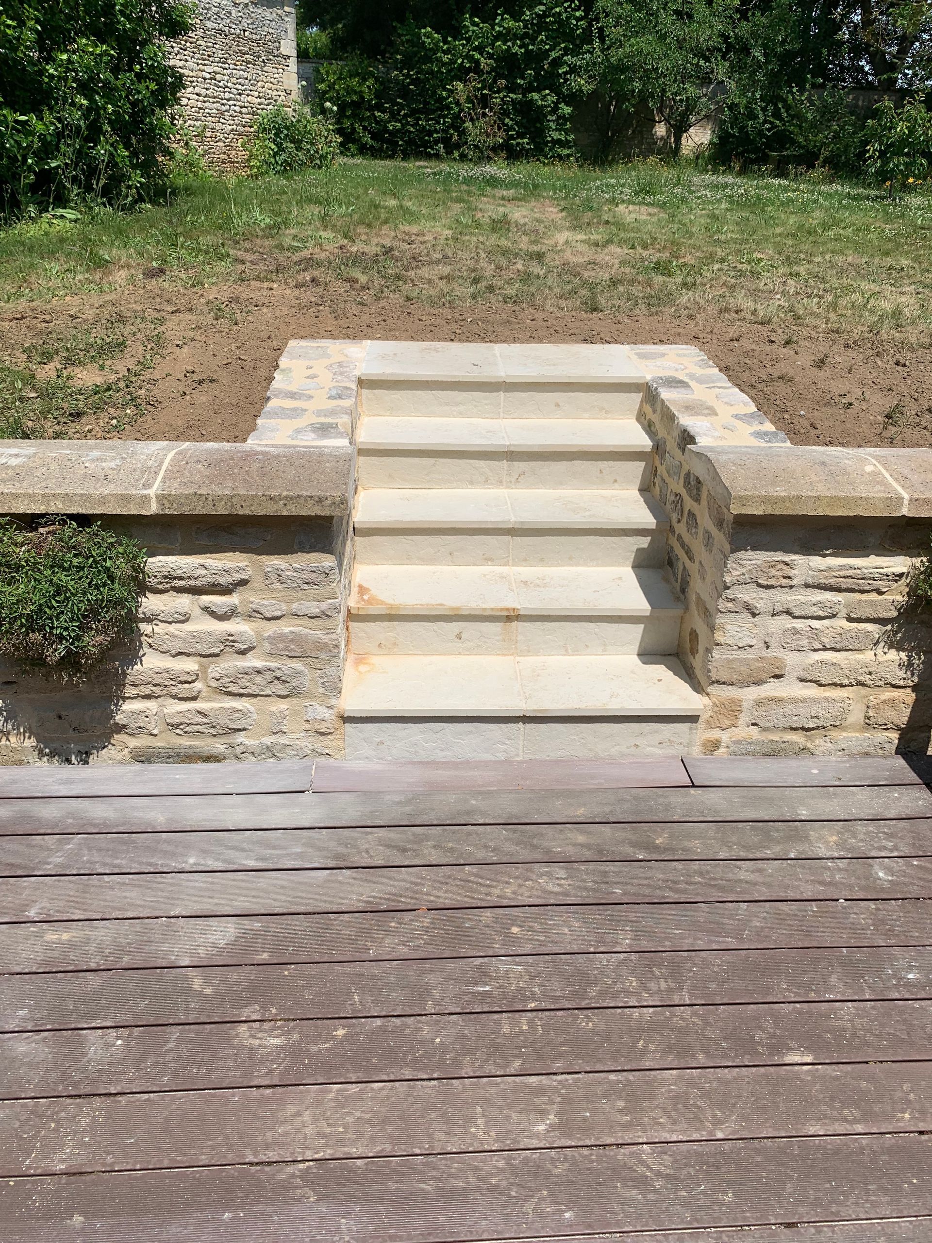 Des escaliers en béton et une terrasse en bois