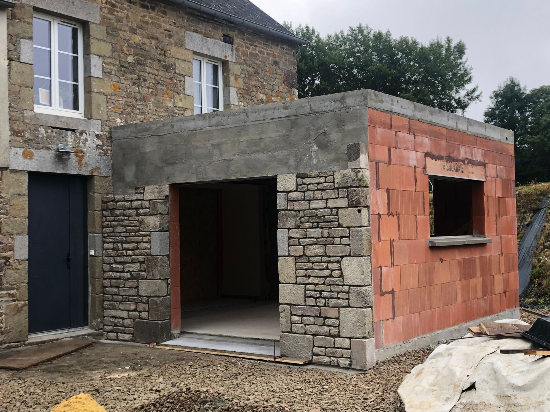 Extension en brique en cours de parement pierre