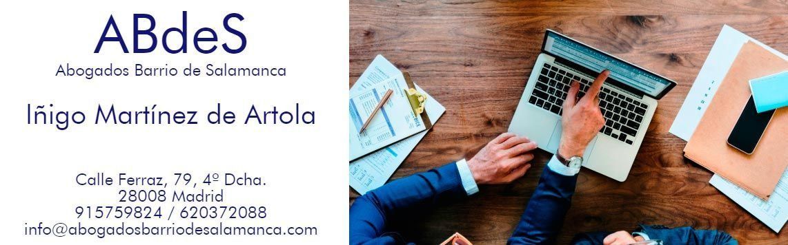 Una tarjeta de visita con texto junto a una persona usando un ordenador portátil sobre un escritorio de madera.