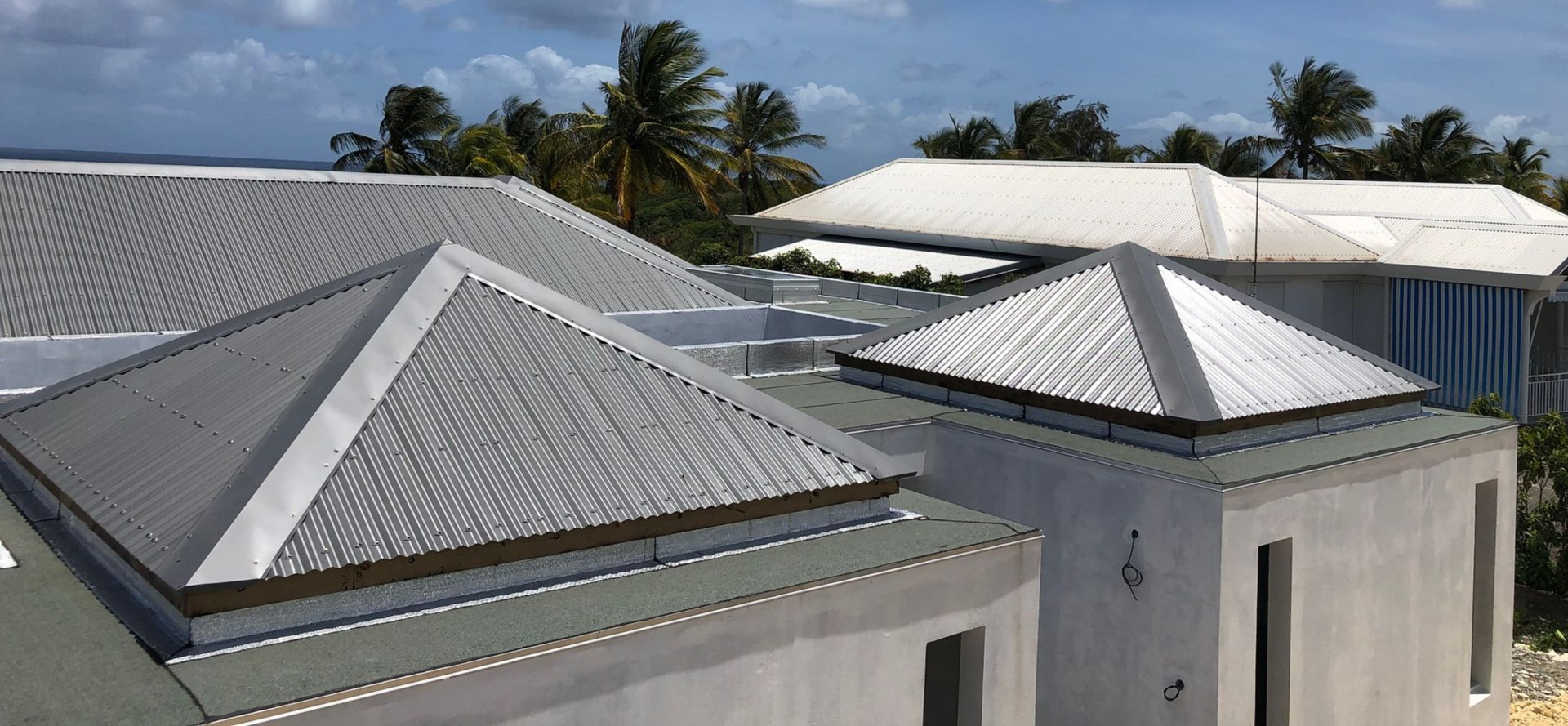 Des maisons aux façades colorées nichées à flanc de colline verdoyante et luxuriante.