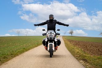 Fahrschule Tischmacher GmbH Fahrschüler auf einem Motorrad mit neuem Führerschein in der Hand